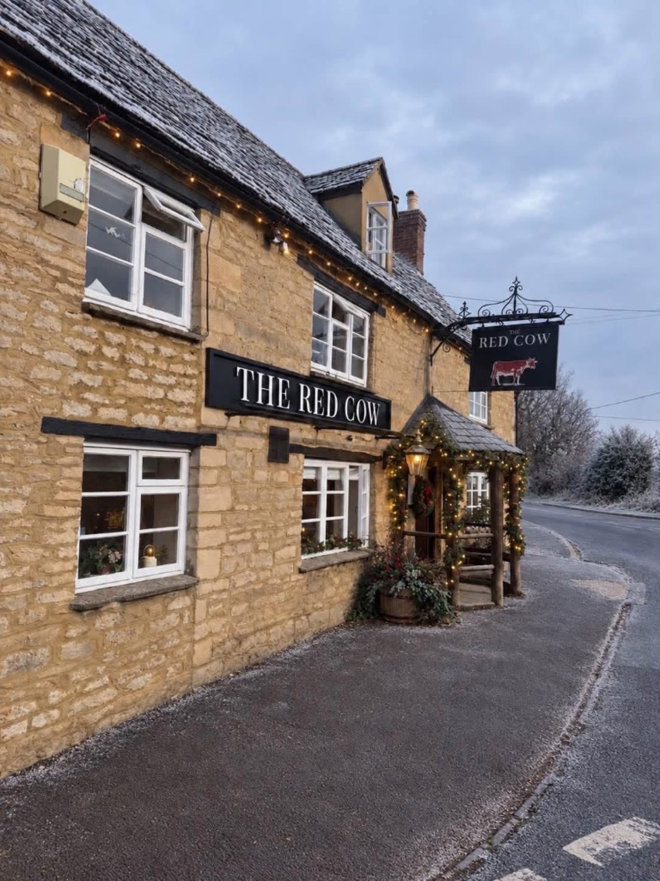 The Red Cow exterior decorated with Christmas lights and garlands