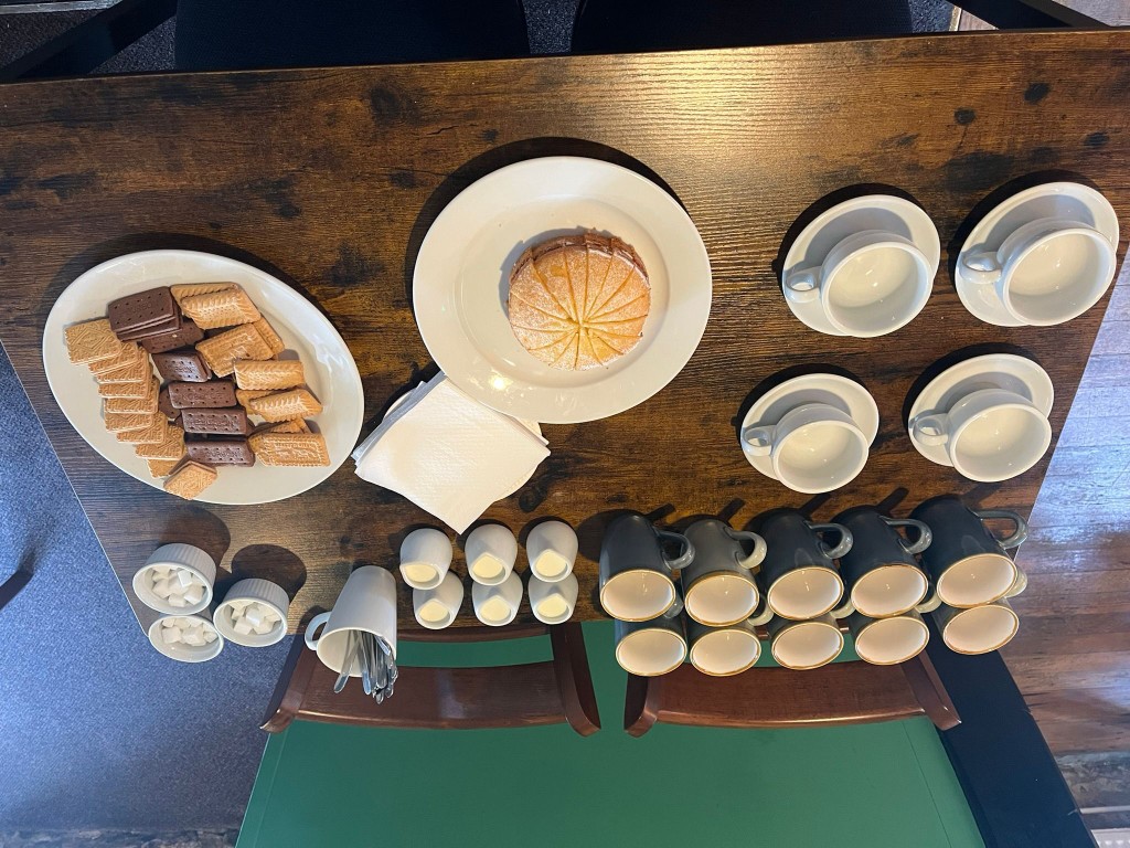 Coffee afternoon at The Red Cow with cakes, biscuits and mugs on the table